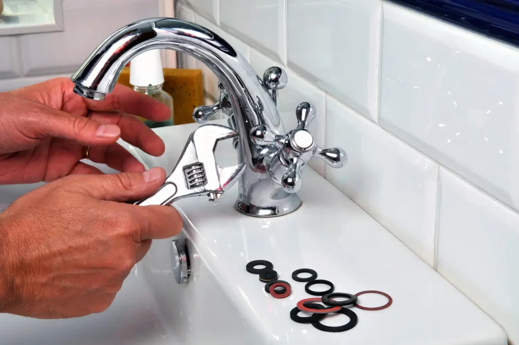 Plumber performing maintenance on a bathroom faucet in York