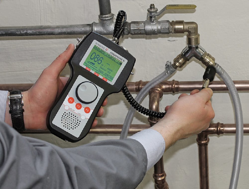 Plumber testing pipes with electronic leak detection equipment in York